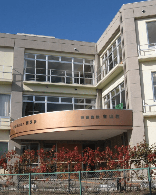介護施設の建物外観。モダンな造りの多層階建築で、銅製の看板が目印。